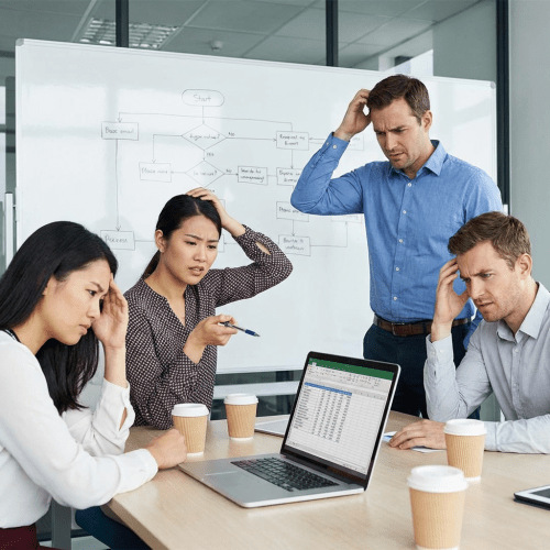 Office workers looking confused while reviewing data on a laptop and whiteboard flowchart.